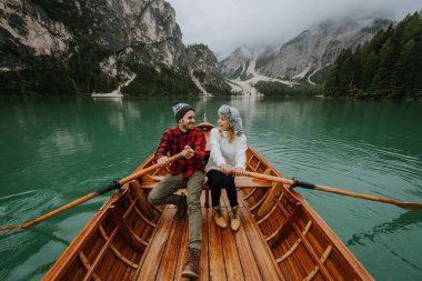 Braies, İtalya 'da bir dağ gölünü ziyaret eden genç ve güzel bir çift - sonbahar yaprakları arasında tatil yapan yürüyüş kıyafetli turistler - seyahat, yaşam tarzı ve seyahat tutkusu kavramları