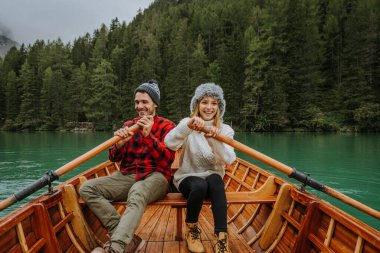 Braies, İtalya 'da bir dağ gölünü ziyaret eden genç ve güzel bir çift - sonbahar yaprakları arasında tatil yapan yürüyüş kıyafetli turistler - seyahat, yaşam tarzı ve seyahat tutkusu kavramları