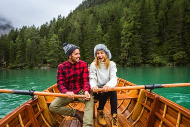 Braies, İtalya 'da bir dağ gölünü ziyaret eden genç ve güzel bir çift - sonbahar yaprakları arasında tatil yapan yürüyüş kıyafetli turistler - seyahat, yaşam tarzı ve seyahat tutkusu kavramları