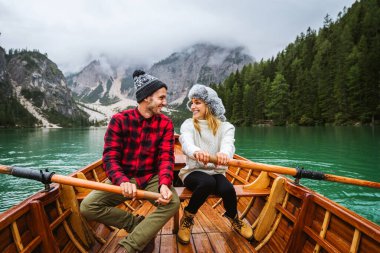 Braies, İtalya 'da bir dağ gölünü ziyaret eden genç ve güzel bir çift - sonbahar yaprakları arasında tatil yapan yürüyüş kıyafetli turistler - seyahat, yaşam tarzı ve seyahat tutkusu kavramları