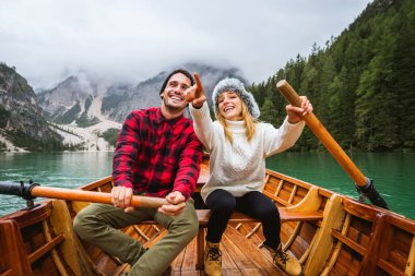 Braies, İtalya 'da bir dağ gölünü ziyaret eden genç ve güzel bir çift - sonbahar yaprakları arasında tatil yapan yürüyüş kıyafetli turistler - seyahat, yaşam tarzı ve seyahat tutkusu kavramları