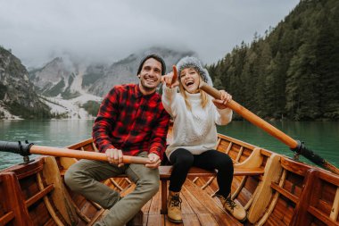 Braies, İtalya 'da bir dağ gölünü ziyaret eden genç ve güzel bir çift - sonbahar yaprakları arasında tatil yapan yürüyüş kıyafetli turistler - seyahat, yaşam tarzı ve seyahat tutkusu kavramları
