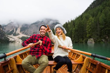 Braies, İtalya 'da bir dağ gölünü ziyaret eden genç ve güzel bir çift - sonbahar yaprakları arasında tatil yapan yürüyüş kıyafetli turistler - seyahat, yaşam tarzı ve seyahat tutkusu kavramları
