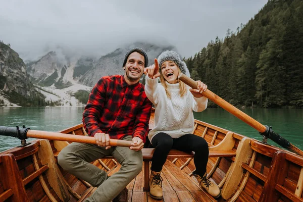 Braies, İtalya 'da bir dağ gölünü ziyaret eden genç ve güzel bir çift - sonbahar yaprakları arasında tatil yapan yürüyüş kıyafetli turistler - seyahat, yaşam tarzı ve seyahat tutkusu kavramları
