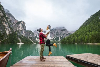 Braies, İtalya 'da bir dağ gölünü ziyaret eden genç ve güzel bir çift - sonbahar yaprakları arasında tatil yapan yürüyüş kıyafetli turistler - seyahat, yaşam tarzı ve seyahat tutkusu kavramları