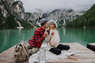 Braies, İtalya 'da bir dağ gölünü ziyaret eden genç ve güzel bir çift - sonbahar yaprakları arasında tatil yapan yürüyüş kıyafetli turistler - seyahat, yaşam tarzı ve seyahat tutkusu kavramları