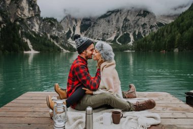 Braies, İtalya 'da bir dağ gölünü ziyaret eden genç ve güzel bir çift - sonbahar yaprakları arasında tatil yapan yürüyüş kıyafetli turistler - seyahat, yaşam tarzı ve seyahat tutkusu kavramları