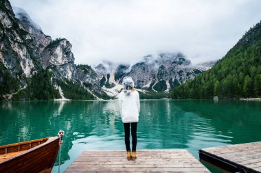 Güzel bir kadın Braies, İtalya 'da bir alp gölünü ziyaret ediyor - Yürüyüş kıyafetli bir turist sonbahar yaprakları arasında tatilde eğleniyor - seyahat, yaşam tarzı ve seyahat tutkusu kavramları