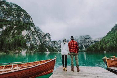 Braies, İtalya 'da bir dağ gölünü ziyaret eden genç ve güzel bir çift - sonbahar yaprakları arasında tatil yapan yürüyüş kıyafetli turistler - seyahat, yaşam tarzı ve seyahat tutkusu kavramları
