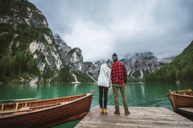 Braies, İtalya 'da bir dağ gölünü ziyaret eden genç ve güzel bir çift - sonbahar yaprakları arasında tatil yapan yürüyüş kıyafetli turistler - seyahat, yaşam tarzı ve seyahat tutkusu kavramları