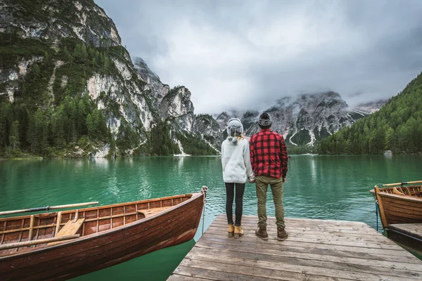 Braies, İtalya 'da bir dağ gölünü ziyaret eden genç ve güzel bir çift - sonbahar yaprakları arasında tatil yapan yürüyüş kıyafetli turistler - seyahat, yaşam tarzı ve seyahat tutkusu kavramları