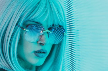 Öncü bir panele poz veren güzel bir genç kadının görüntüsü. Alternatif görünümlü ve gri peruklu genç şehir portreleri yapıyor.