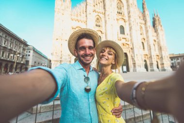 Tatildeki mutlu bir çiftin görüntüsü. Genç bir adam ve kadın Milan 'da Duomo katedralinin yakınında selfie çekiyorlar.