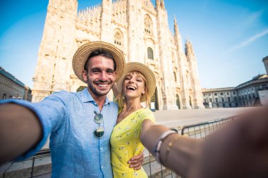 Tatildeki mutlu bir çiftin görüntüsü. Genç bir adam ve kadın Milan 'da Duomo katedralinin yakınında selfie çekiyorlar.