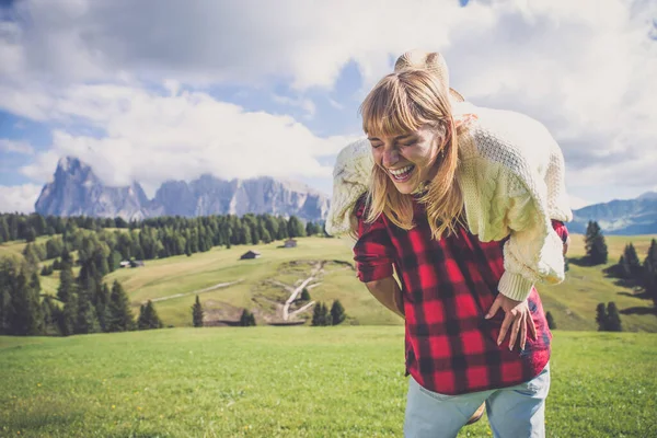 イタリアのドロマイト山脈での休暇に幸せなカップル 若い男と女が一緒に緑の草原で遊んでいる — ストック写真