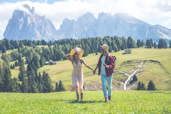 イタリアのドロマイト山脈での休暇に幸せなカップル 美しい緑の草原で活動する若い男と女 — ストック写真