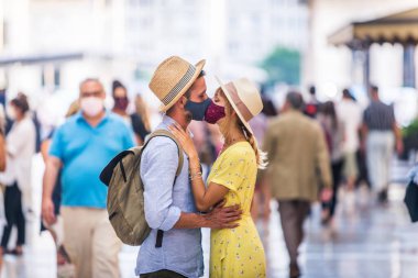Koruyucu maskeler takan ve öpüşen güzel bir çift, covid-19 salgını sırasında, yaşam tarzı, salgın çağı ve sosyal uzaklık kavramları hakkında