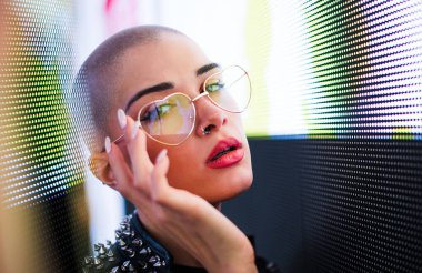 Şık elbiseli güzel bir kız ışıkların yanında poz veriyor - Güzel kadın portresi