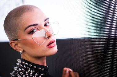 Şık elbiseli güzel bir kız ışıkların yanında poz veriyor - Güzel kadın portresi