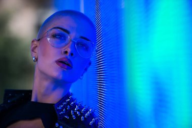 Şık elbiseli güzel bir kız ışıkların yanında poz veriyor - Güzel kadın portresi