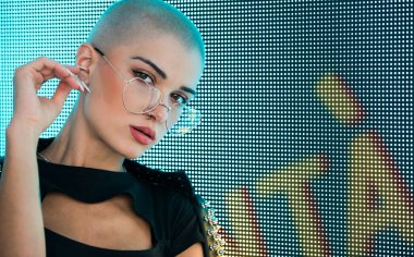 Şık elbiseli güzel bir kız ışıkların yanında poz veriyor - Güzel kadın portresi