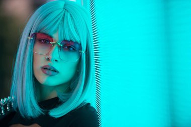 Şık elbiseli güzel bir kız ışıkların yanında poz veriyor - Güzel kadın portresi