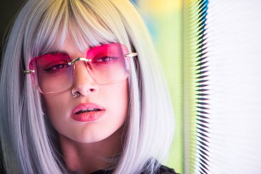 Şık elbiseli güzel bir kız ışıkların yanında poz veriyor - Güzel kadın portresi