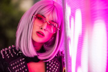 Şık elbiseli güzel bir kız ışıkların yanında poz veriyor - Güzel kadın portresi