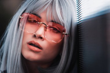 Şık elbiseli güzel bir kız ışıkların yanında poz veriyor - Güzel kadın portresi