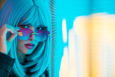 Şık elbiseli güzel bir kız ışıkların yanında poz veriyor - Güzel kadın portresi