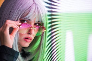 Şık elbiseli güzel bir kız ışıkların yanında poz veriyor - Güzel kadın portresi