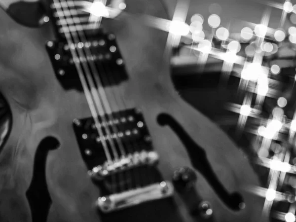 semi scoustic jazz guitar closeup with amp and bokeh lighting in background
