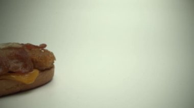 Lezzetli taze çizburger. Aşçı üstte yatar. Bir çanaktan mayonez sıkılarak çıkarılmış. Yakın plan..