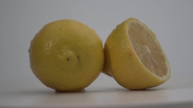 Meyveli limonlar tabakta döner. Beyaz arka plan. yiyecek