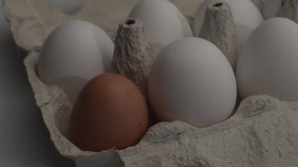 Celda con huevos de pollo de diferente color en la mesa. Panorama. Objeto alimentario — Vídeos de Stock