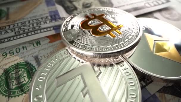 Monedas de plata criptográfica Bitcoin, Ripple y Litecoin sobre la mesa con dólar americano. Billete de 100 dólares. Gire la superficie . — Vídeos de Stock