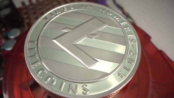 Riesige silberne Cryptocurrency Lite Münzen rotieren auf roter Grafikkarte mit weißem Hintergrund. Einzigartige Makroaufnahme des Geldes. — Stockvideo