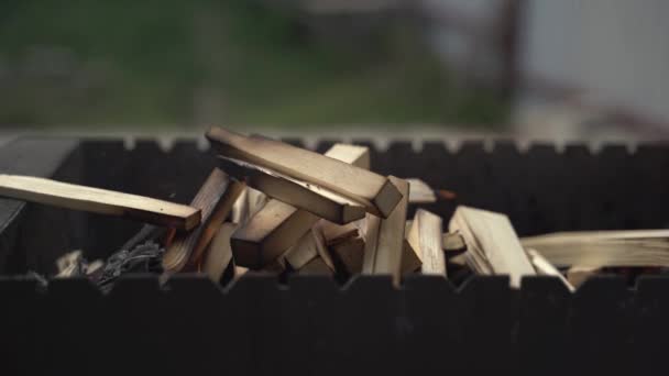 Mano di un uomo bianco mette legna da ardere nel braciere ai carboni già caldi lì — Video Stock