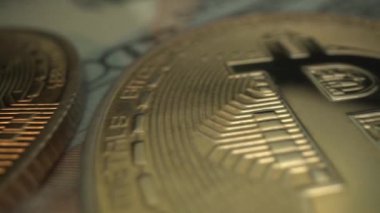 Bitcoin ve USA 100 dolarlık banknot. Masadaki kripto para Laowa 24 mm 'lik süper makroyla çekilmiş. Yarı yarıya
