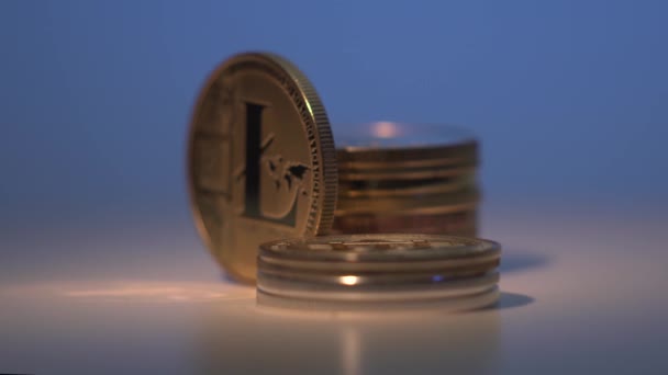 Gold digital coin Litecoin rotate on white surface surrounded by many other cryptocoins. Gradient blue and white background. Mining. Raise of price. Halving. Close up shot — Stock Video