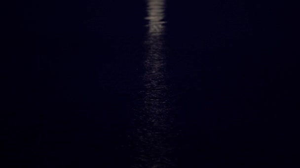 De camera daalt geleidelijk van de maan langs het maanpad naar de kalme blauwe zee om middernacht. — Stockvideo