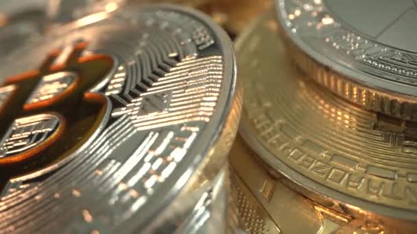 Altın ve Gümüş Bitcoin ve üzerinde güzel bir ışık bulunan başka bir kripto sikke yüzeyde dönüyor. Laowa 24 mm sonda lensinden Macro çekimi. Piyasada ticaret. Yakın plan çekim. Dijital teknoloji. — Stok video