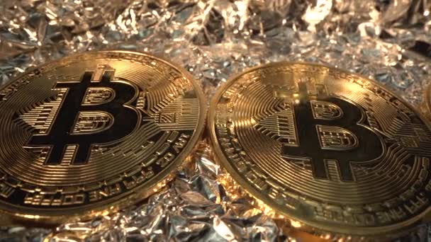 Veel gouden Bitcoin roteren op reflecteren oppervlak. Licht verlicht ze. Digitale munt. Virtuele valuta. Nieuw geld — Stockvideo