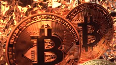 Üç altın kripto bozuk para altın yansıma yüzeyinde döner. Laowa 24 mm sonda lensinden Macro çekimi. Takas yapalım. Madencilik. Yarı yarıya. Bozuk para. Altın rengi. para.