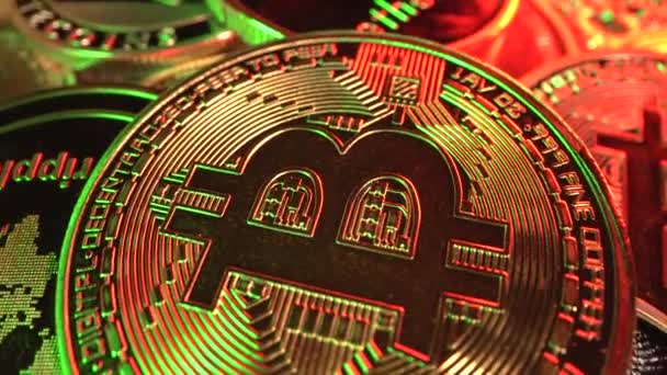 金Bitcoin BTCは緑と赤のリングでテーブルを回転させます。コインは別の暗号コインに囲まれています。マクロユニックショット。取引だ。採掘だ。半分だ。ブロックチェーン. — ストック動画