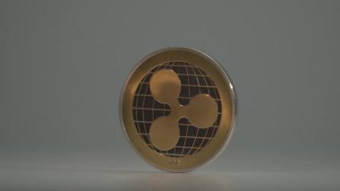 Altın Kripto Para Dalgalanması XRP beyaz arkaplan ile beyaz yüzeyde döner. Yakın çekim. Madencilik. Şifreli paranın yarısı. Geleceğin parası. Engelleme teknolojisi