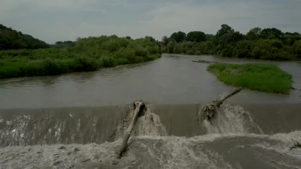 Zicht vanuit de lucht op water dat stroomafwaarts stroomafwaarts stroomt door kunstmatige stroomversnellingen van een waterkrachtcentrale — Stockvideo