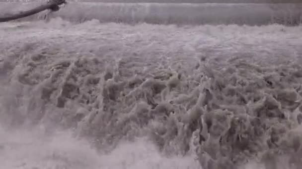 Stroom van het water stroomt naar beneden door waterstroomversnellingen in de buurt van waterkrachtcentrale. close-up drone schot. — Stockvideo