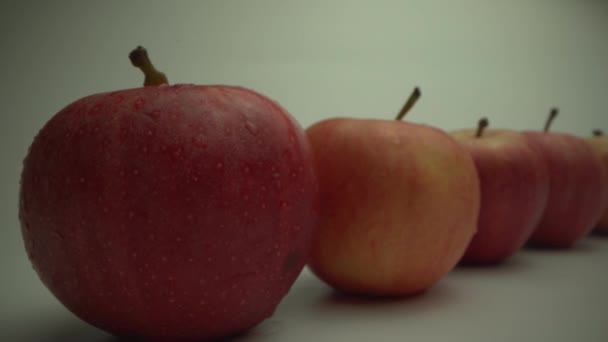 Свежие спелые яблоки на белом столе. Макросъемка из объектива Laowa 24 мм. Саммер. Еда — стоковое видео