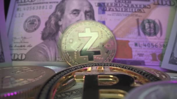 Crypto argent numérique entouré de nombreux dollars américains en lumière au néon. Beaucoup de pièces sur la table. Bitcoin, Zcash, Etherium. Macro shot — Video
